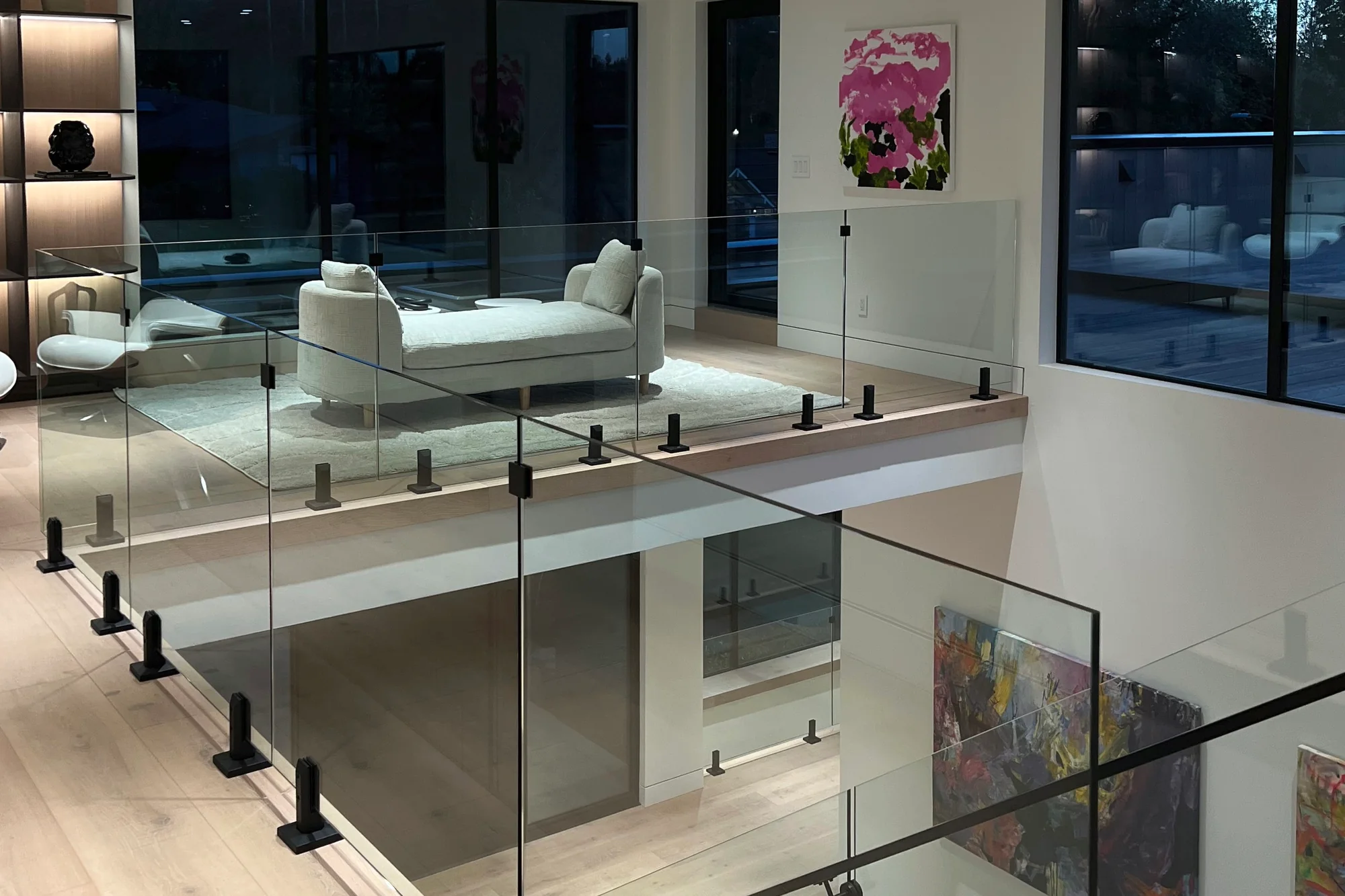 Frameless glass guardrail on black spigots around an upper level stair opening, by IGo Green Enterprises in Clyde Hill, WA