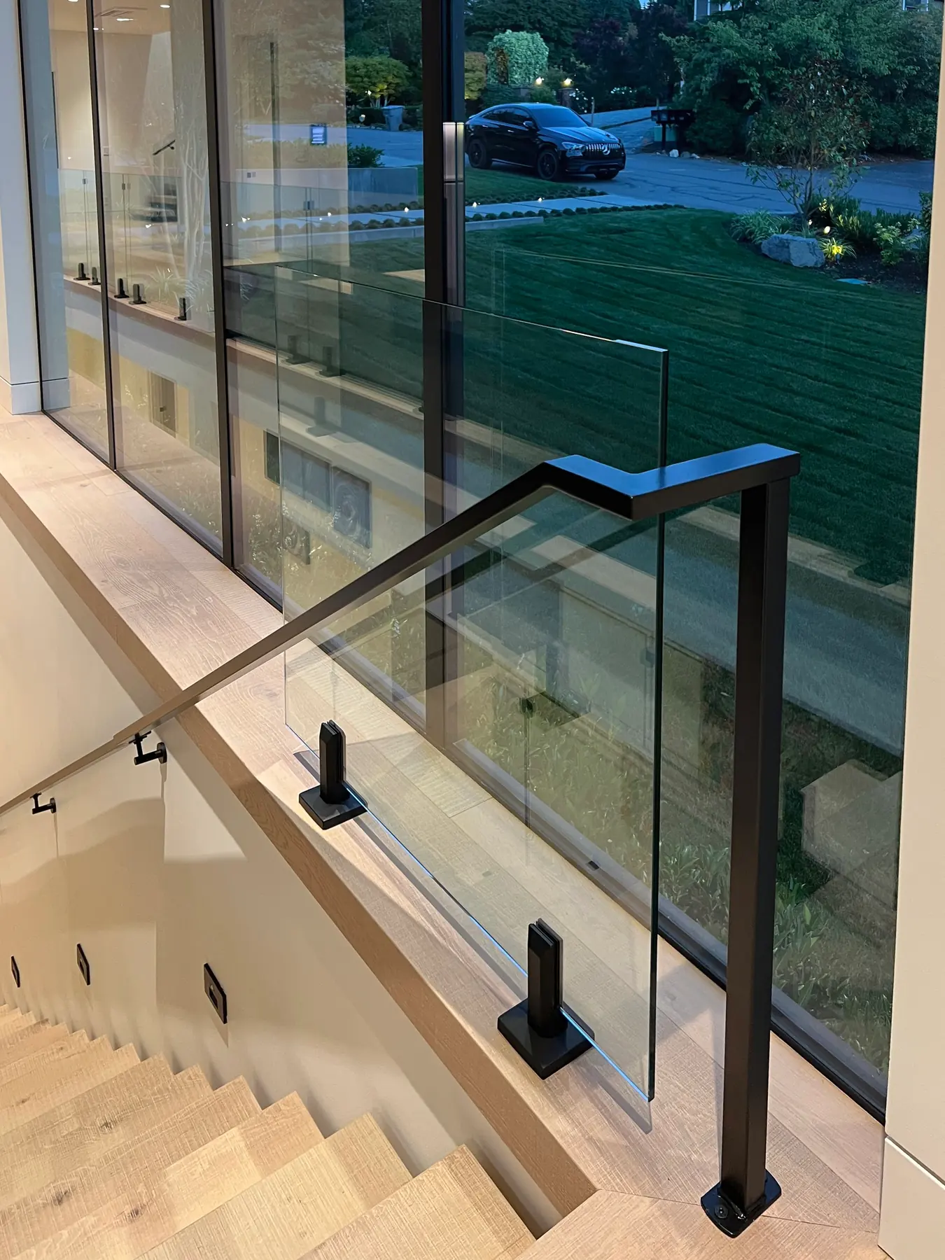 Glass panel and black handrail at a stair window, installed by IGo Green Enterprises in Clyde Hill, WA