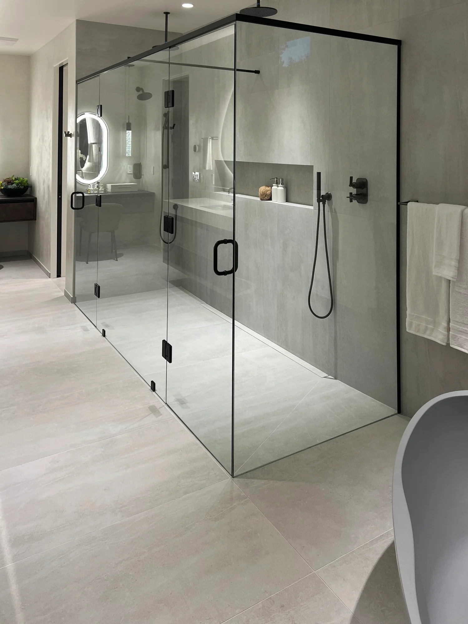 Walk-in frameless shower enclosure with a matte black header in a Clyde Hill, WA master bath, by IGo Green Enterprises